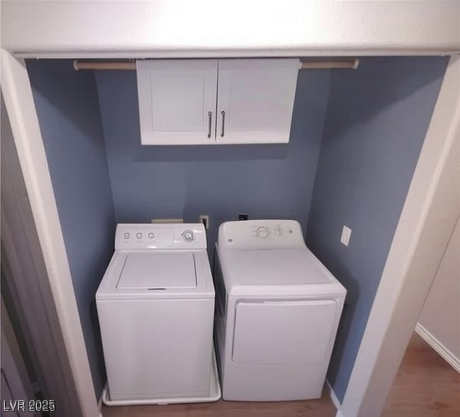 Laundry area with washing machine and dryer, cabinet space, and wood finished floors | Image 21