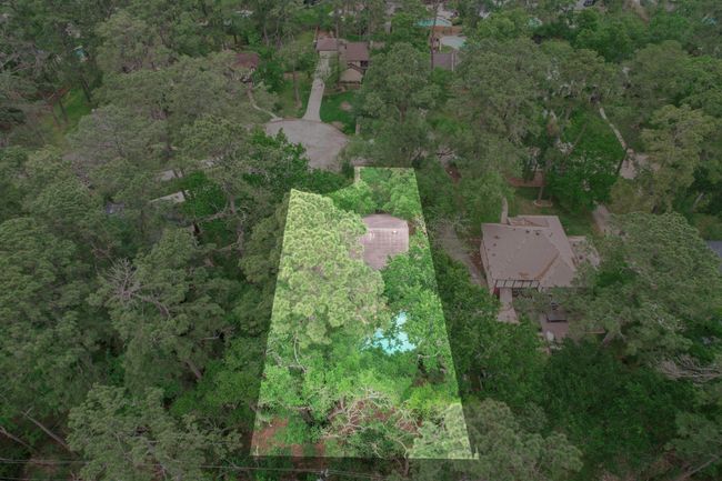 This aerial view highlights a private backyard retreat with a resort-style, in-ground pool, enveloped by lush greenery and mature trees—creating a tranquil and secluded setting. | Image 29