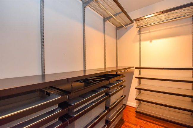 The remodeled primary bedroom closet, featuring custom shelving and hanging racks, offers plenty of storage space and organization. | Image 31