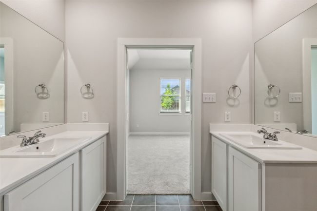 Bathroom featuring tile patterned floors, two vanities, and baseboards | Image 13