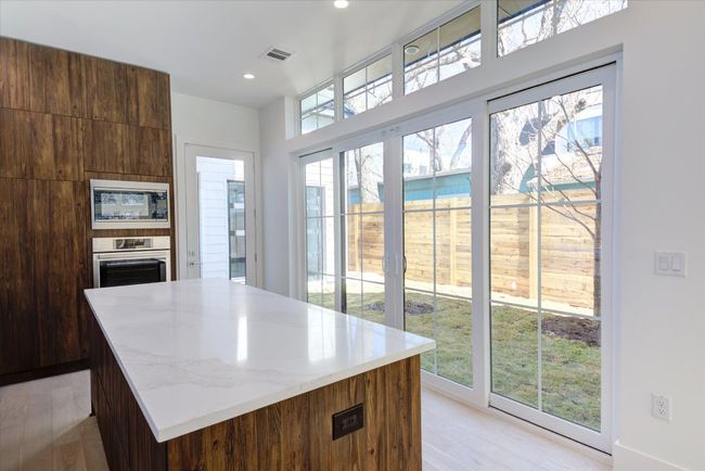 Sliding glass doors off of the kitchen let the sunshine in but can be fully opened to the yard/courtyard area - perfect for entertaining! | Image 14