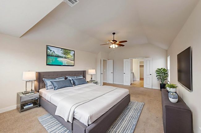 Bedroom featuring light carpet, baseboards, lofted ceiling, and a ceiling fan | Image 12