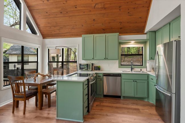 Kitchen featuring vaulted ceiling, a sink, stainless steel appliances, wooden ceiling, and green cabinetry | Image 22