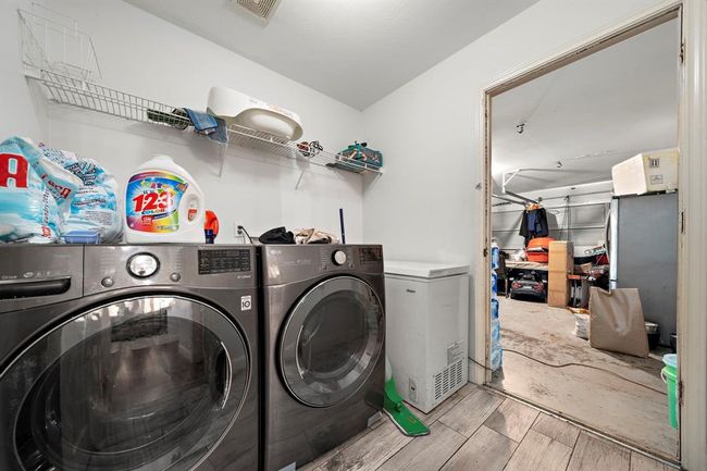 The home includes a dedicated laundry room with direct access to the garage, offering both convenience and functionality for everyday living. Tile-look flooring and wall-mounted shelving make it easy to keep things organized. | Image 30