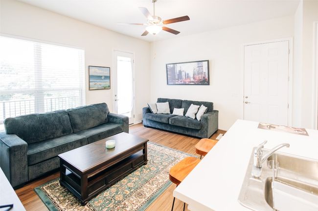 Living area featuring a ceiling fan and wood finished floors | Image 6