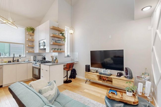 Living room with light wood-style flooring, lofted ceiling, and baseboards | Image 13