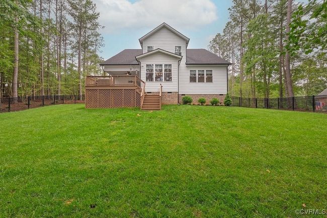 Rear view of property with crawl space, stairway, a fenced backyard, a deck, and roof with shingles | Image 47