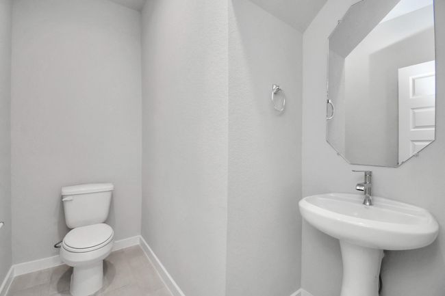 This half bathroom features a stylish pedestal sink, modern hardware, and bright recessed lighting, creating a sleek and inviting space. | Image 8