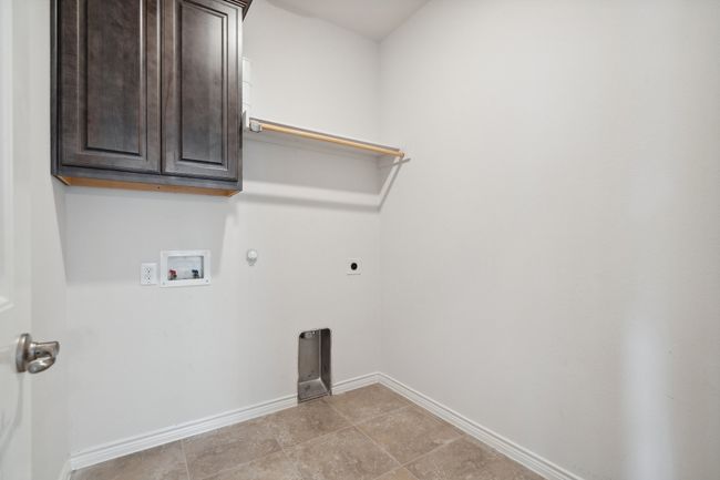 Laundry area featuring electric dryer hookup, hookup for a washing machine, gas dryer hookup, and cabinet space | Image 25
