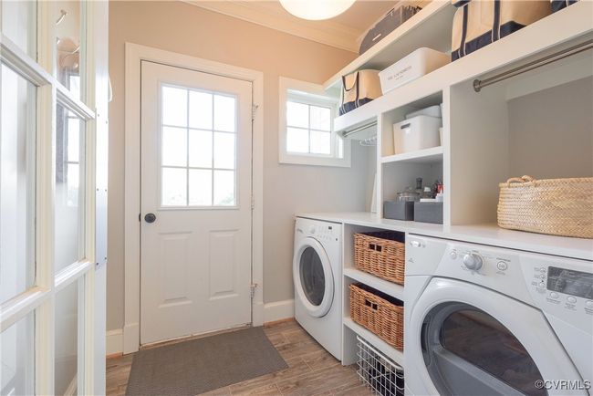 Laundry area featuring laundry area, light wood-type flooring, ornamental molding, baseboards, and washing machine and dryer | Image 22