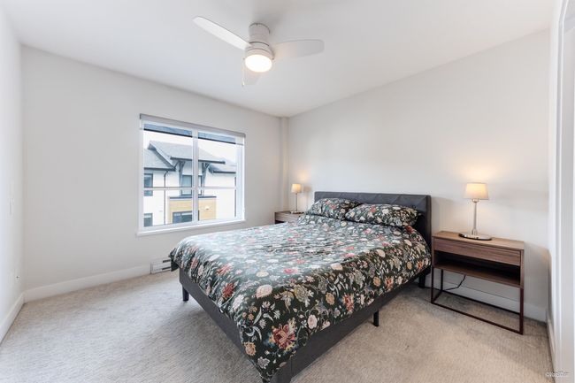 Carpeted bedroom with a ceiling fan, baseboard heating, and baseboards | Image 21