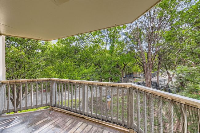 Wooden deck with view of wooded area, access from living room and bedroom. | Image 14