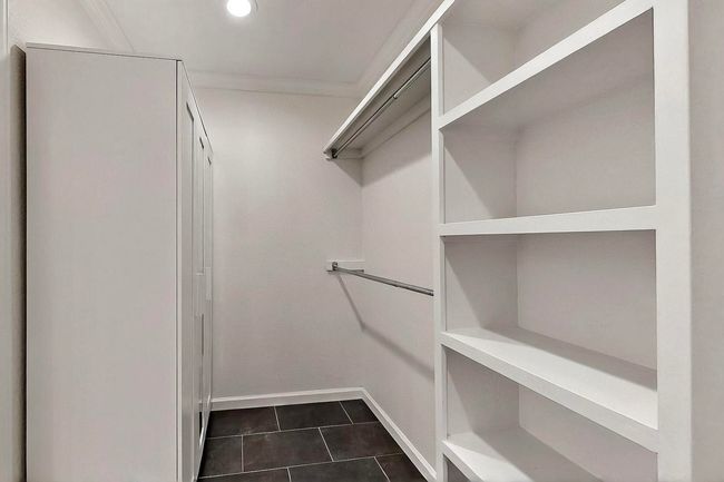 Walk in closet featuring dark tile patterned floors | Image 36