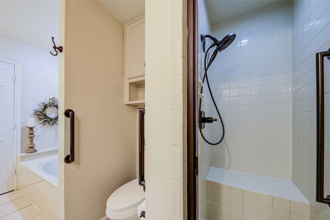 Bathroom with tiled shower, a bath, and tile patterned flooring | Image 22