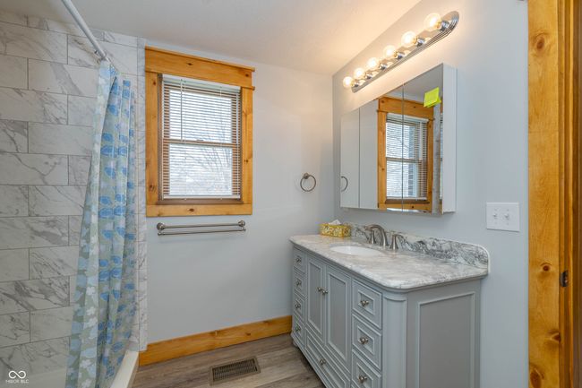 bathroom featuring visible vents, curtained shower, baseboards, wood finished floors, and vanity | Image 8