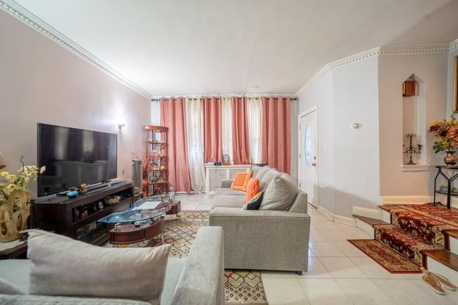 Tiled living area featuring crown molding and baseboards | Image 5