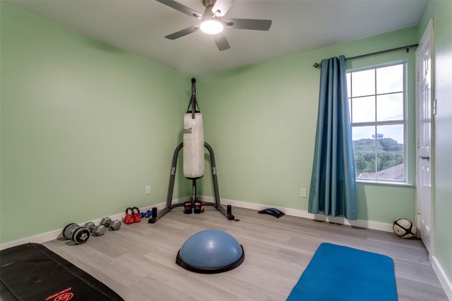 Workout area featuring a ceiling fan, wood finished floors, and baseboards | Image 22