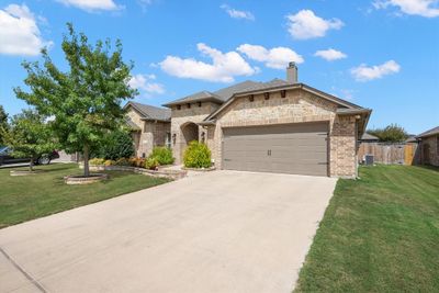 View of front of property featuring a garage, a front yard, and cooling unit | Image 3