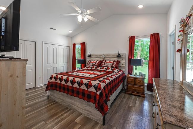 Bedroom with vaulted ceiling, multiple closets, dark wood-style flooring, recessed lighting, and ceiling fan | Image 15
