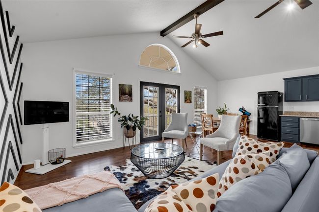 Living area featuring french doors, high vaulted ceiling, beamed ceiling, a ceiling fan, and wood finished floors | Image 23