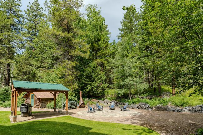 View of grassy yard with a patio area and a forest view | Image 16