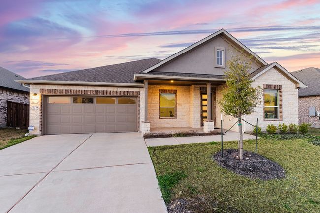View of front facade with a lawn, driveway, stone siding, a shingled roof, and a garage | Image 6