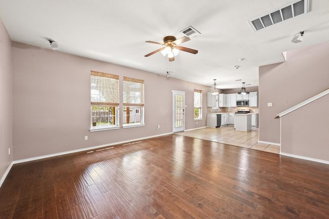 Unfurnished living room featuring a ceiling fan and light wood finished floors | Image 9