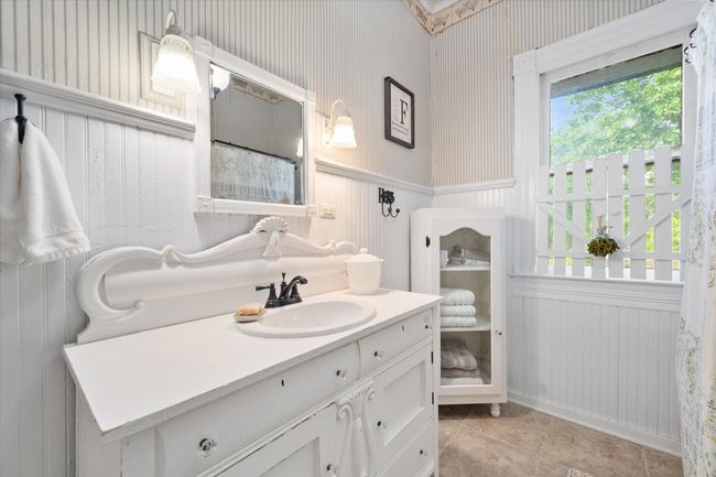 Bathroom featuring wainscoting, vanity, wallpapered walls, and tile patterned flooring | Image 31