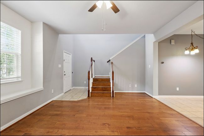 Foyer featuring stairway, ceiling fan with notable chandelier, wood finished floors, and a wealth of natural light | Image 8
