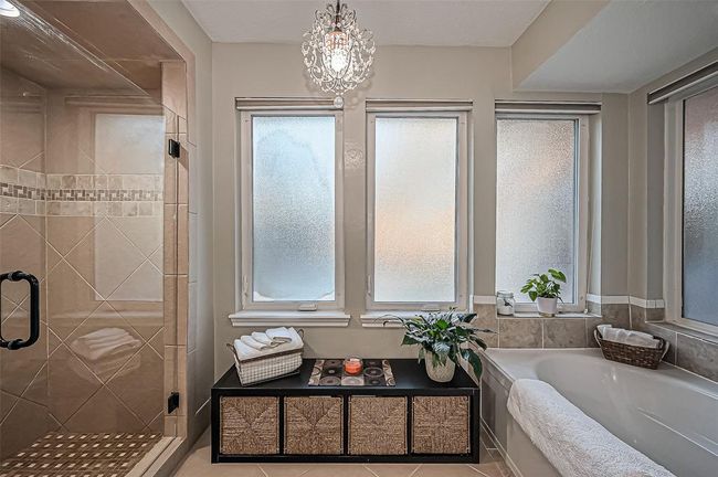 Indulge in your own spa-like oasis, highlighted by a stunning chandelier. | Image 31