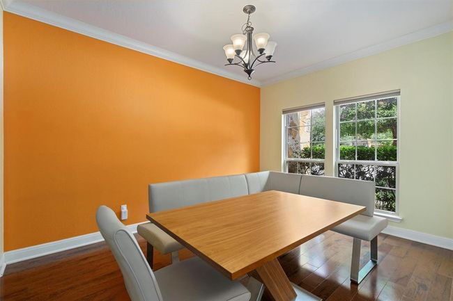 Dining space featuring a chandelier, dark wood finished floors, baseboards, and crown molding | Image 8