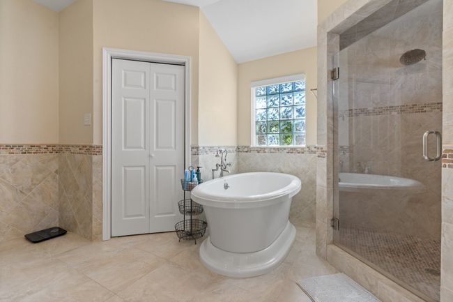 Primary Bathroom featuring DEEP Soaking Tub, tile patterned floors, tile walls, and independent shower and bath | Image 27