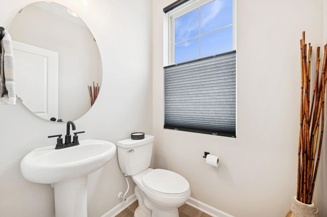 Bright and simple half bathroom on the main level, featuring a sleek sink and toilet—perfectly convenient for homeowners and guests during entertaining. | Image 37