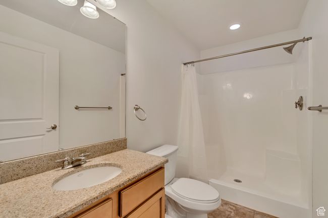 Bathroom with a shower with shower curtain, toilet, and vanity | Image 16