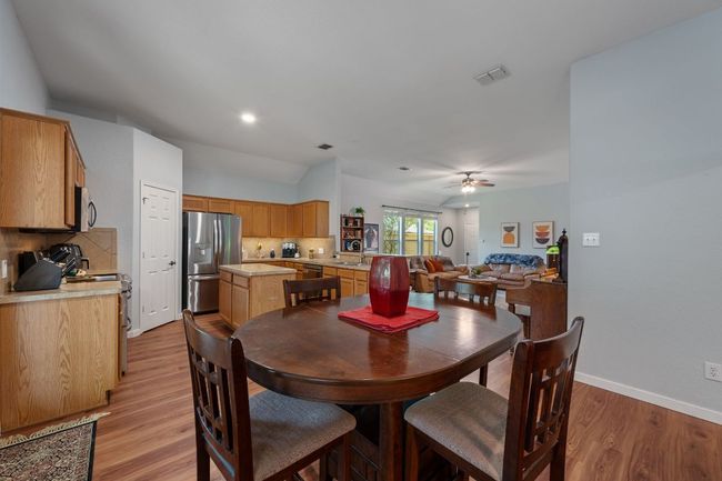 Dining space with light wood-style floors, ceiling fan, baseboards, and vaulted ceiling | Image 14