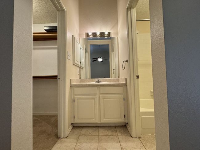 Bathroom featuring shower / bath combination, ceiling fan, vanity, and tile floors | Image 16