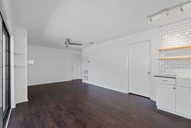 The living room and kitchen are wrapped in crown molding with an updated modern ceiling fan to keep the breeze flowing. | Image 13