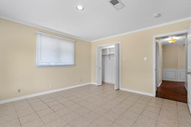 Unfurnished bedroom with ornamental molding, light tile patterned flooring, and a closet | Image 25