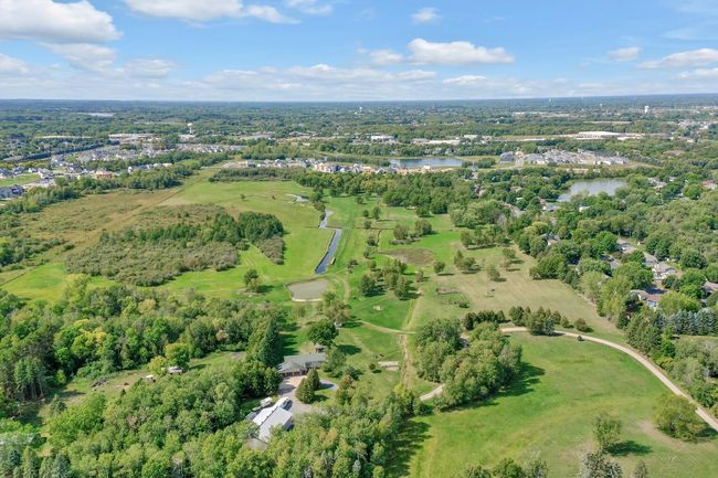 Westerly view, Driveway on the right side of photo and pole building roof and house a little left of bottom center. Land extends back to wetlands on the west and south prior to development areas. | Image 6