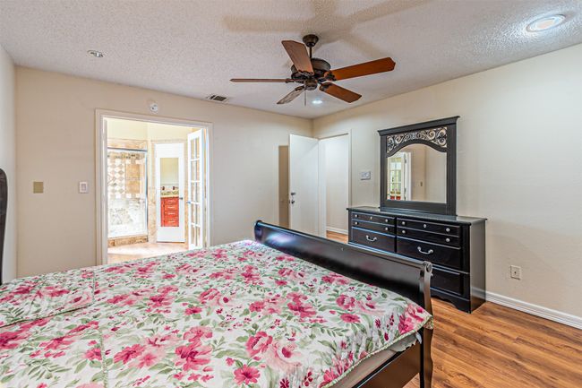 Bedroom featuring wood finished floors, ceiling fan, a textured ceiling, and recessed lighting | Image 17