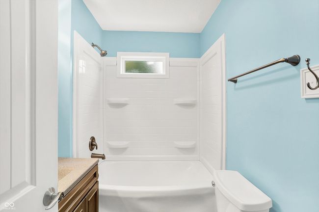 bathroom with toilet, vanity, and tub / shower combination | Image 13