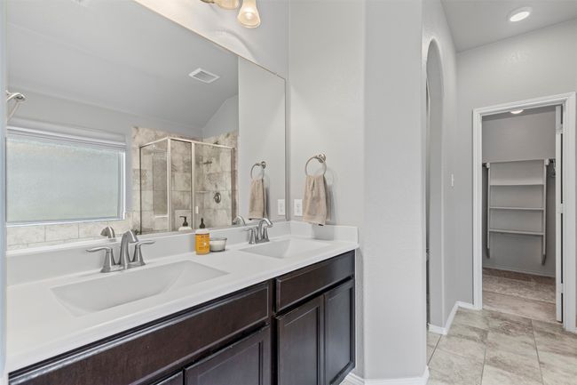 Bathroom with a stall shower, separate tub, double vanity, and lofted ceiling | Image 15
