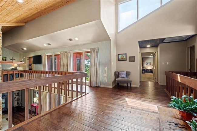 Hall featuring wood finished floors, a towering ceiling, recessed lighting, and an upstairs landing | Image 19