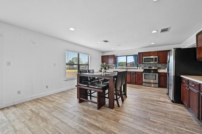 Dining room featuring light wood finished floors, baseboards, and recessed lighting | Image 13