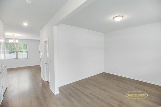 Empty room with a chandelier, baseboards, and wood finished floors | Image 8