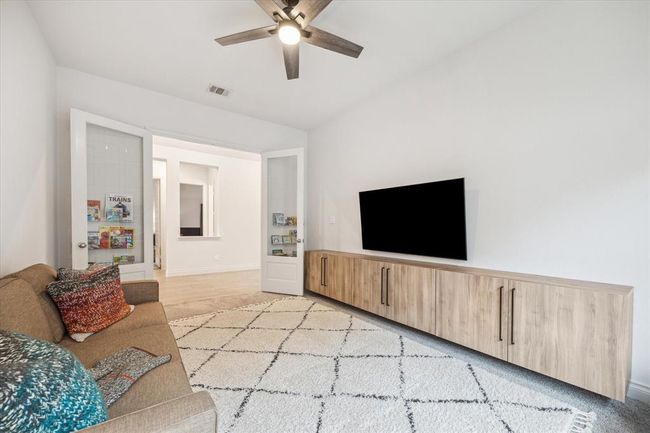 Here’s a different angle of this spacious and versatile flex space, you’ll love the high ceilings, ceiling fan, and the ample room for a cozy sofa. Whether you envision a stylish home office, a peaceful reading lounge, or a creative retreat, this space is designed to inspire. | Image 5