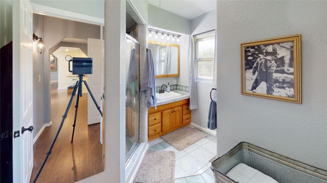 Full bath featuring a textured wall, vanity, a shower stall, and light tile patterned floors | Image 26