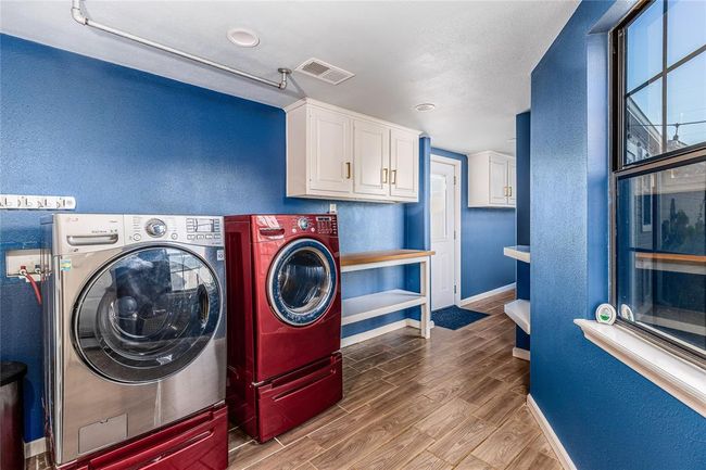 The laundry room is located in the enclosed walkway between the house and the garage | Image 34