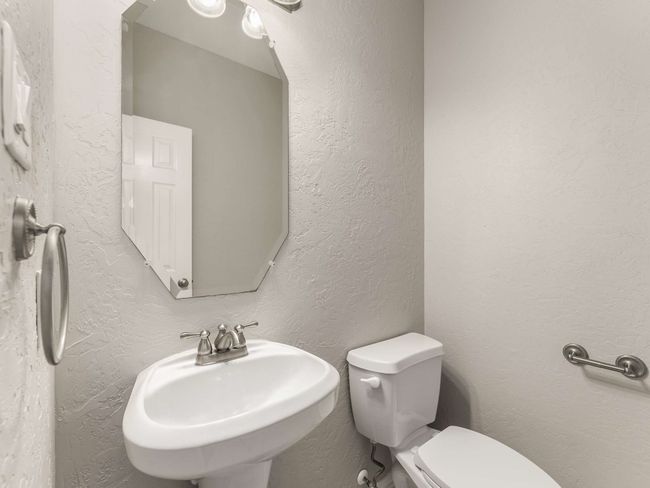 Half bath featuring toilet, a textured wall, and a sink | Image 21