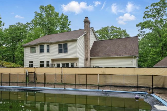 Rear view of house with a chimney and a fenced backyard | Image 48